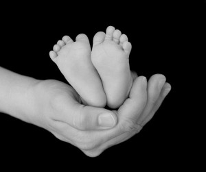 Newborn's Feet Cradled in Parent's Hand