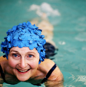 Elderly Woman Smiling Wearing a Swimming Cap in a Swimming Pool