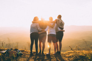 friends hugging over cliff