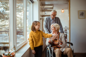 women in wheelchair with husband and granddaughter