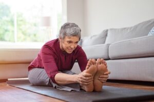 Mature woman doing yoga exercise at home